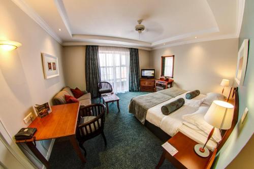 伊丽莎白港Courtyard Hotel Gqeberha的配有一张床和一张书桌的酒店客房
