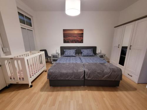 奥伯豪森Wohnung in Oberhausen: zentral & ruhig, eigener Eingang的一间卧室配有一张床和一张婴儿床