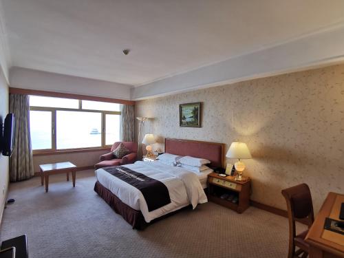 青岛青岛泛海名人酒店的酒店客房,配有床和沙发