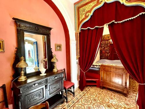 苏塞Dar Aziz的一间带镜子的卧室和一张带红色窗帘的床
