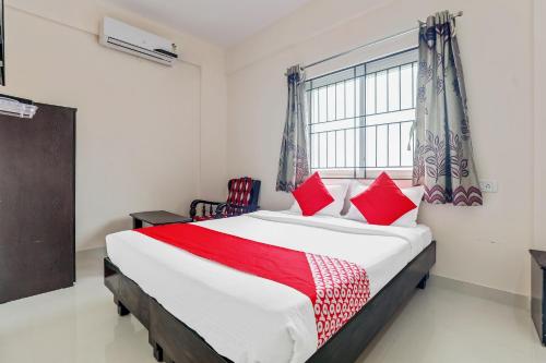 班加罗尔49996 JJ Comforts的一间卧室配有一张带红色枕头的大床