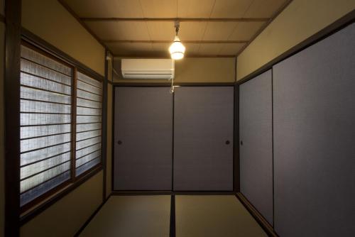 京都Gion House的一间空房间,有白色的门和光线