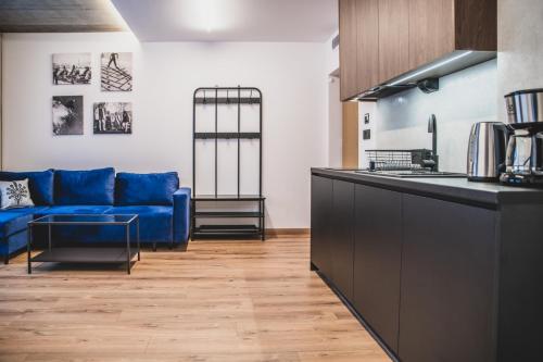 扎科帕内Apartamenty Górski Kryształ的厨房以及带蓝色沙发的起居室。