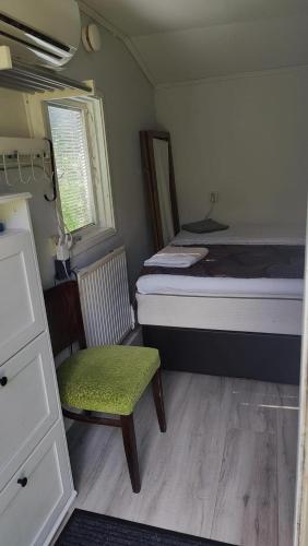 GustavsvikMinivilla in Gustavsvik Nacka的小房间,配有一张床和一把椅子