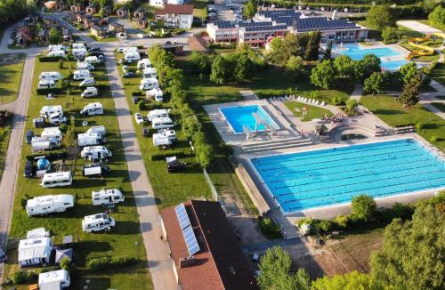 纳堡Tinyhaushotel - Campingpark Nabburg的享有停车场空中景致,设有游泳池