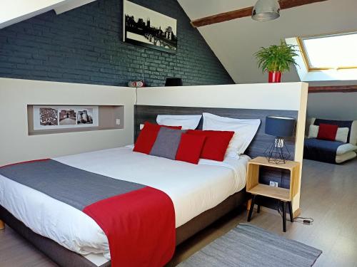 昂热Les Suites Angevines的一间卧室配有一张带红色和蓝色枕头的大床