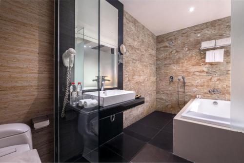 三宝垄三宝垄酒店的浴室配有盥洗盆、卫生间和浴缸。