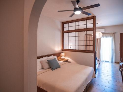 帕尔加Dracos Hotel的一间卧室配有一张带吊扇的床
