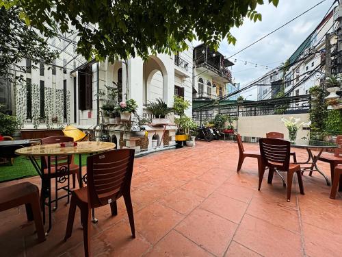河内Tuna Homestay Hanoi & Experience的庭院内带桌椅的庭院。