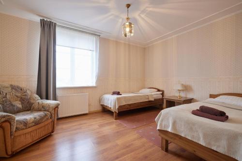 拉克韦雷Villa Wesenbergh的客房设有两张床、一张沙发和一个窗口。