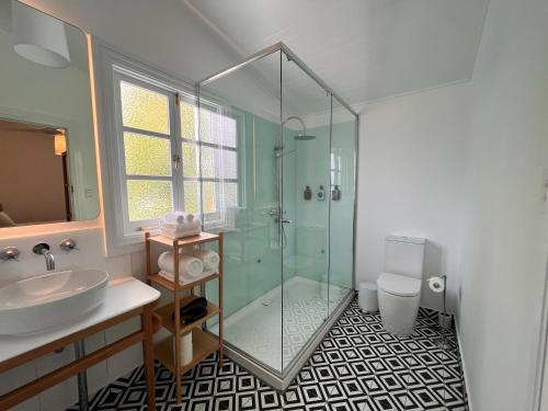 凯恩斯Floriana Boutique Hotel的一间带玻璃淋浴和水槽的浴室