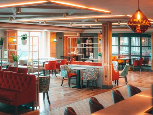 波塔当Seagoe Hotel的一间设有红色桌椅的餐厅和一间酒吧