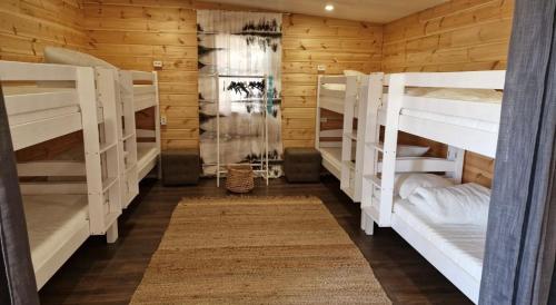 NurmijärviKodikas mökki lähellä luontoa Nurmijärven Perttulassa的小屋内带白色双层床的房间