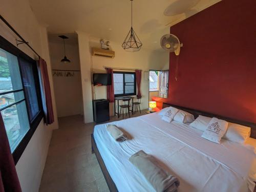 涛岛Goodtime Utopia Guesthouse的卧室配有一张白色大床和红色墙壁