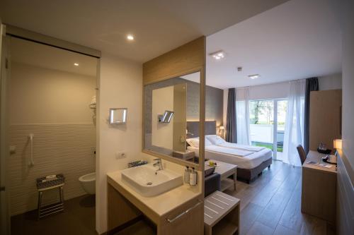 加尔达湖滨贝拉丽瓦酒店的一间带水槽、床和镜子的浴室