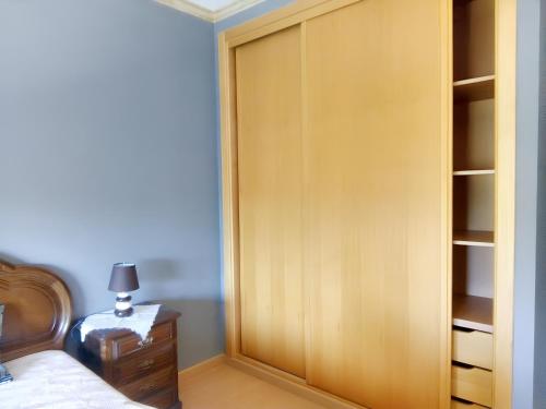 Urqueira2 bedrooms apartement with enclosed garden and wifi at Urqueira的卧室内的衣柜,配有一张床和一盏灯