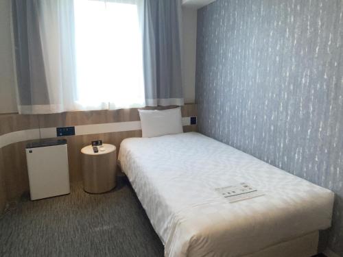 小松市Henn na Hotel Komatsu Ekimae的小房间设有床和窗户