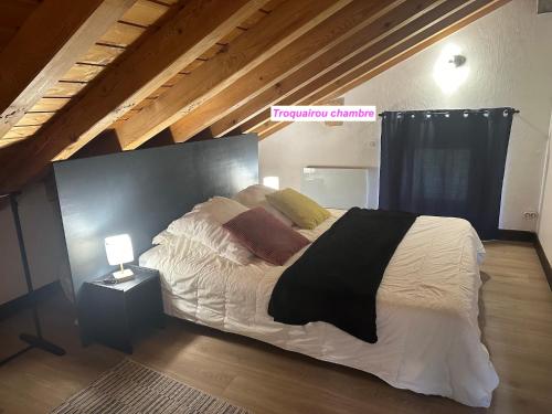 布里德莱班MAISON DES VIGNES- TROQUAÏROU et BECCA MOTTA的卧室配有一张带白色床单和枕头的大床。