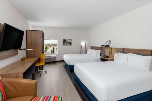 埃尔帕索La Quinta Inn & Suites by Wyndham El Paso East Loop-375的一间酒店客房,设有两张床和电视