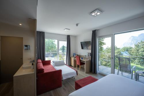 加尔达湖滨贝拉丽瓦酒店的酒店客房设有红色的沙发和大窗户