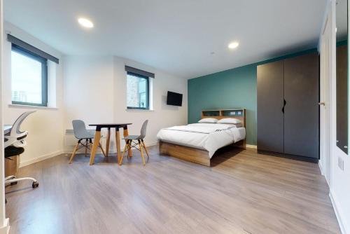 伦敦Private Bedrooms with Shared Kitchen, Studios and Apartments at Canvas Wembley in London的卧室配有一张床和一张桌子及椅子