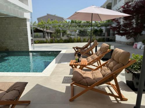 乌尔齐尼Marini Casa的游泳池旁的两把椅子和一把遮阳伞