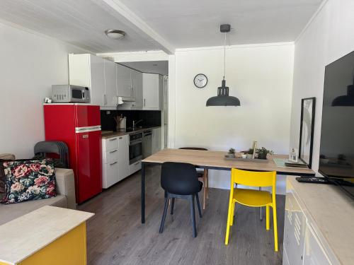 高尔Sentrumsvegen - Private Studio Apartment in Gol的厨房配有桌子、两把椅子和红色冰箱。