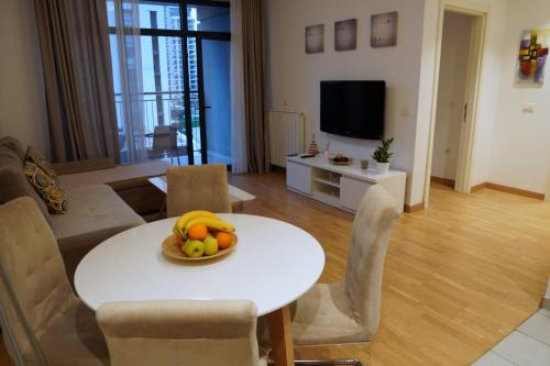贝尔格莱德Belgrade Waterfront Comfortable Apartment的客厅里设有一张桌子,上面放着一碗水果