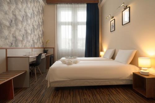 尼赖吉哈佐卡罗纳酒店的酒店客房设有一张白色大床和一张书桌