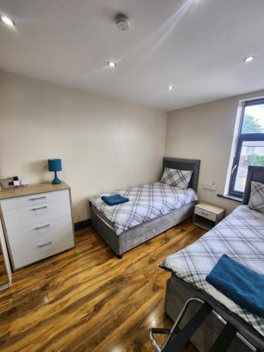 曼彻斯特133 A Park Road的一间卧室设有两张床,铺有木地板