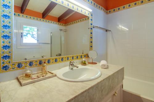 松霍里吉尔Ca Nura - Dúplex con piscina y a pasitos del mar的一间带水槽和镜子的浴室