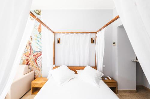 格里莫Le Suffren Hôtel的卧室配有2张床和白色墙壁