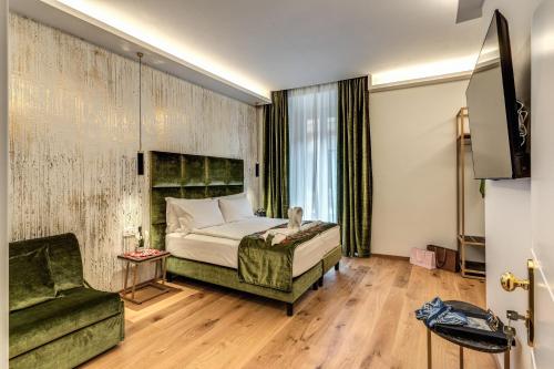 罗马Goldoni 47的一间卧室配有一张床、一把椅子和一张沙发