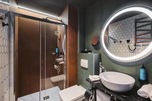 华沙Stay inn Hotel Warszawa的带淋浴、盥洗盆和镜子的浴室