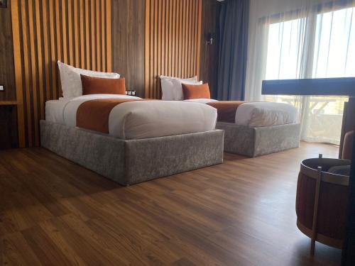 盖尼特拉Razane Hôtel的酒店客房内设有两张床和一张沙发。