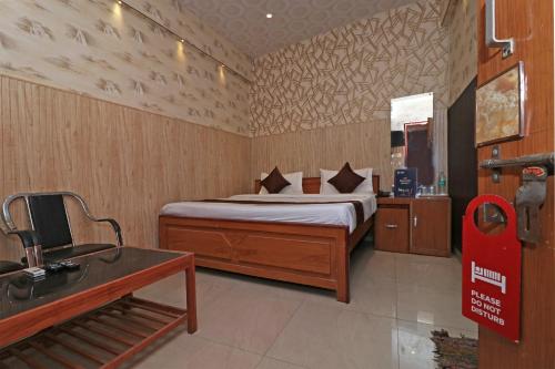 BijnaurOYO 13234 Hotel Mahak的一间卧室配有一张床和一张书桌