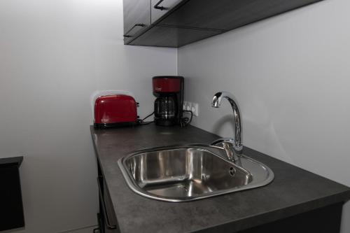 格仑达积图迪斯山林小屋的厨房柜台设有水槽和红色的用具