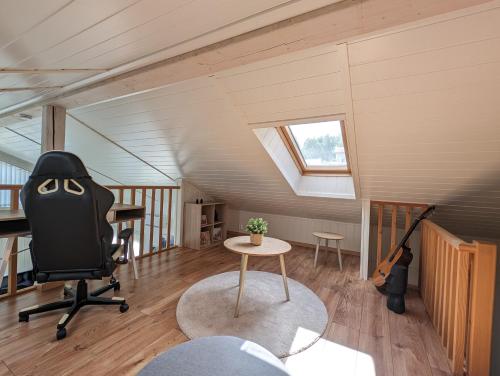 VidnesLovely home by Glomma river!的阁楼间配有书桌、椅子和吉他