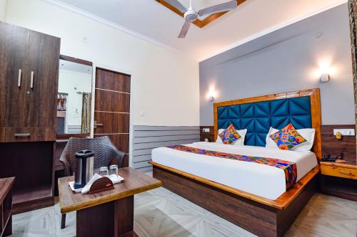 MājraFabHotel KK Residency的一间卧室配有一张大床、一张桌子和一把椅子