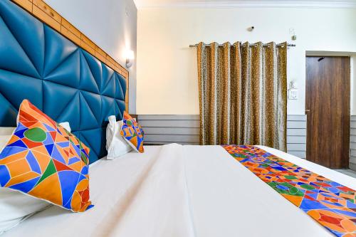 MājraFabHotel KK Residency的一间卧室配有一张大床和蓝色床头板