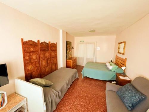 图德拉Pensión las Hojas的一间带两张床和一张沙发的客厅