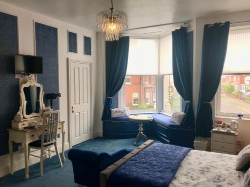 惠特比Norman Guest House with Free Parking的一间卧室配有蓝色窗帘、一张床和窗户