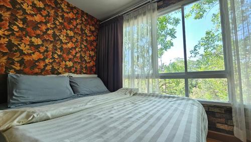卡图Plus 2 Condo Phuket by ABCD的一间卧室设有一张床和一个大窗户