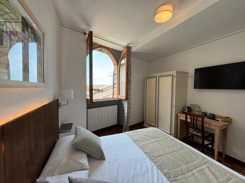 阿西西Hotel La Fortezza的一间卧室配有一张床、一个窗口和一张书桌