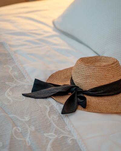 塔拉斯孔普罗旺斯马斯迪斯康帝思酒店的床上的带黑丝带的草帽