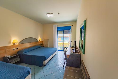 兰佩杜萨Hotel Baia Turchese的一间卧室配有一张床和一张书桌及电视