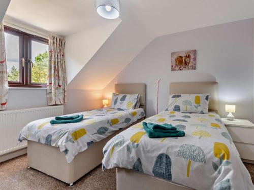 Stoborough4 Bed in Wareham 77511的一间卧室设有两张床和窗户。