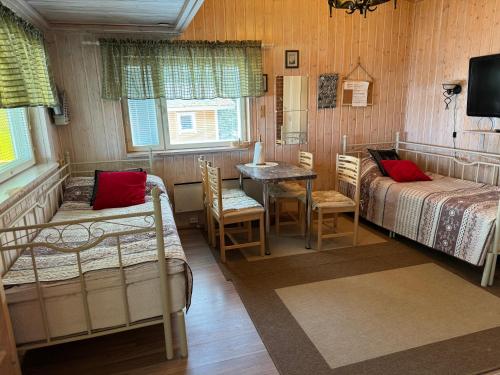 VerlaVerlan Satumaa的一间卧室配有两张床和一张桌子及椅子