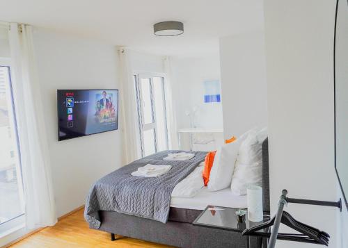 汉诺威At home in the inner city的卧室配有一张床铺,墙上配有电视