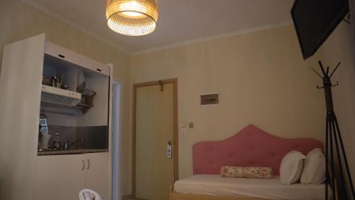萨尔蒂维克酒店的一间卧室配有一张带粉红色床头板和灯的床。